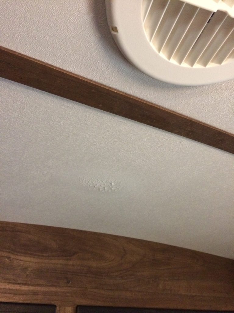 view of condensation formed on the ceiling with an a/c vent close by