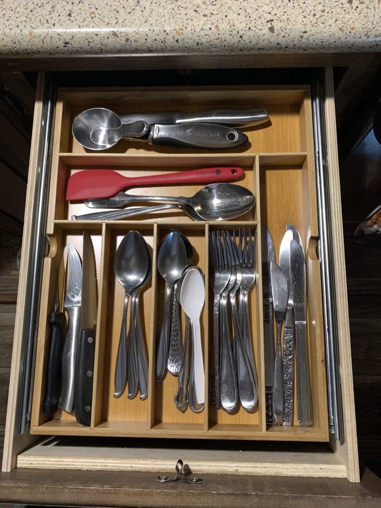 View of the drawer full of utensils