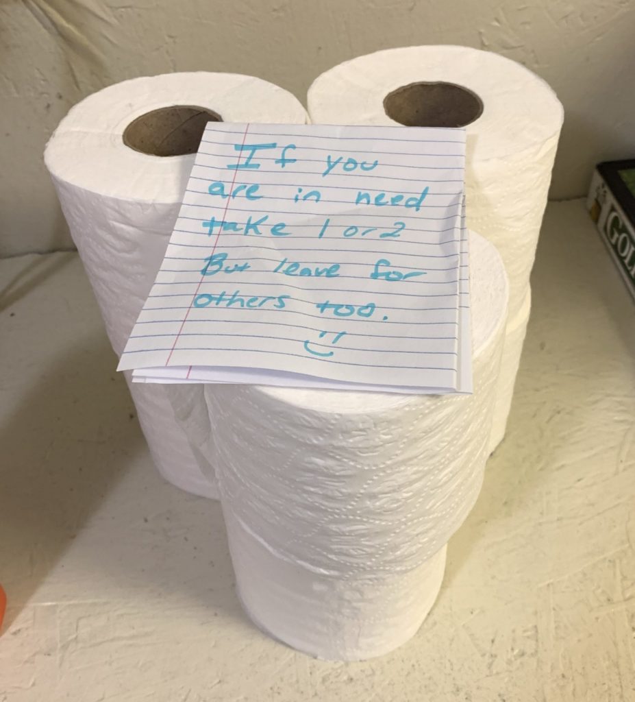 a stack of 6 rolls of toilet paper and a note that says "if you are in need, take 1 or 2, but leave some for others too :)"