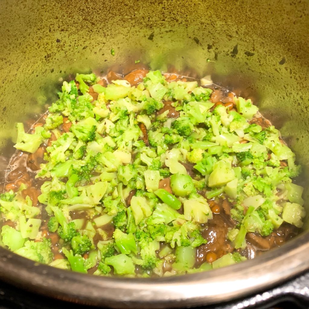 A steaming casserole dish with a layer of broccoli  