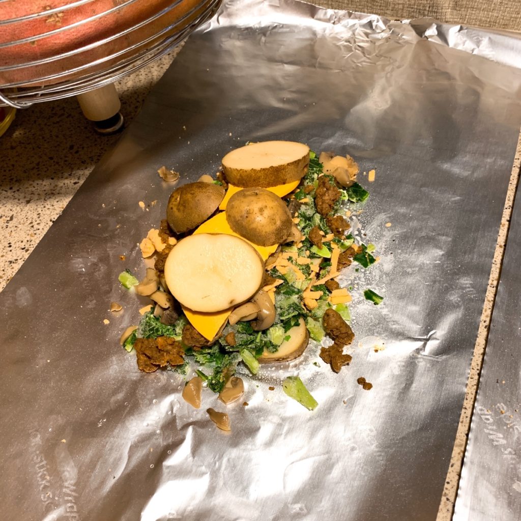 A piece of foil with a pile of food on top   