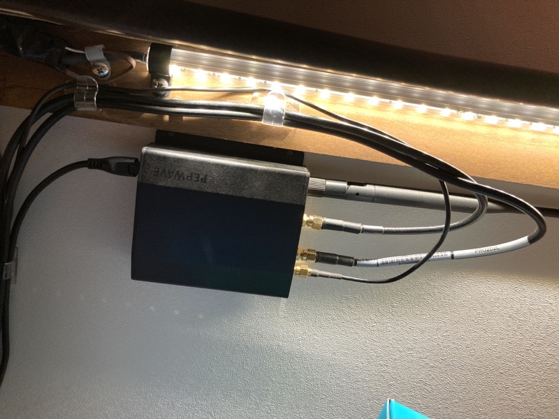 A black box with wires coming from it mounted to a ceiling. 