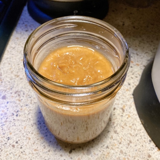 A glass jar with caramel sauce