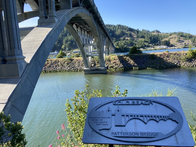 A bridge spanning a river, with a Patterson Bridge placard. 